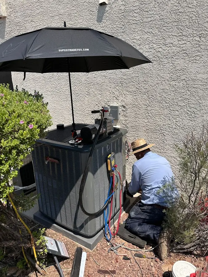 HVAC technician performing outdoor AC maintenance in Vinton
